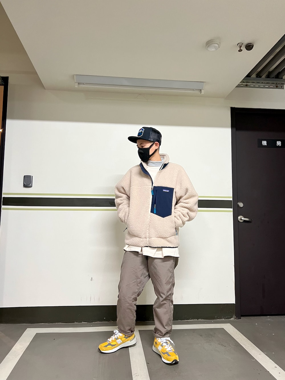 ベージュ系のダウンジャケット/コート、イエロー系のスニーカー、グレー系のチノパンツを着用したメンズの冬コーディネートの2枚目の写真