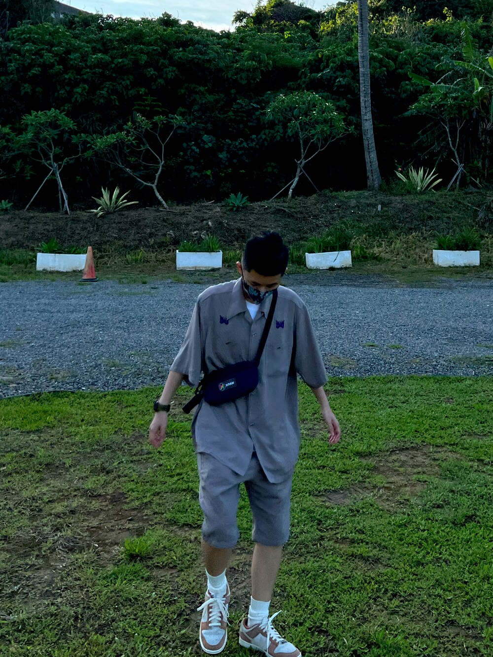 ピンク系のスニーカー、ブルー系のボディバッグ/ウエストポーチ、ベージュ系のシャツ/ブラウスを着用したメンズの夏コーディネートの2枚目の写真