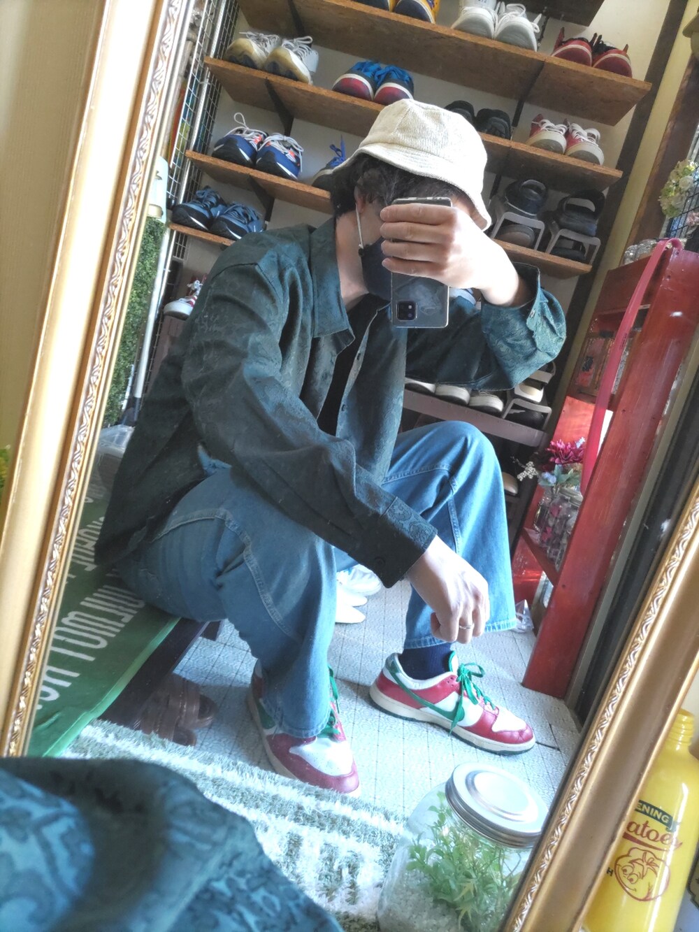 ブルー系のデニムパンツ、レッド系のスニーカー、グリーン系のシャツ/ブラウスを着用したメンズの春コーディネートの3枚目の写真