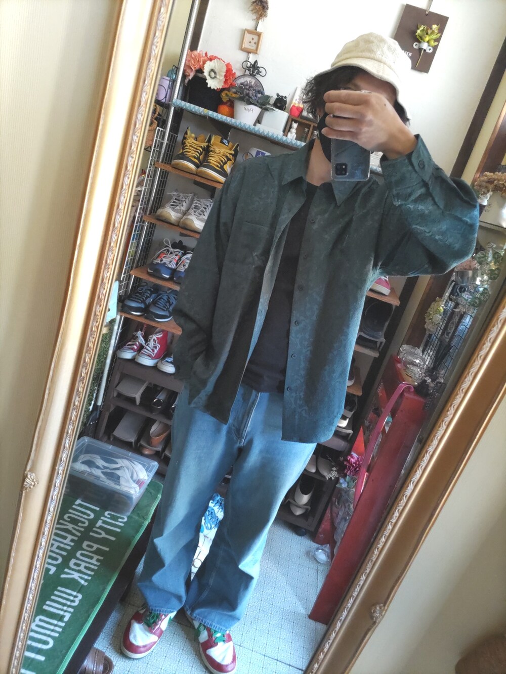 ブルー系のデニムパンツ、レッド系のスニーカー、グリーン系のシャツ/ブラウスを着用したメンズの春コーディネートの2枚目の写真