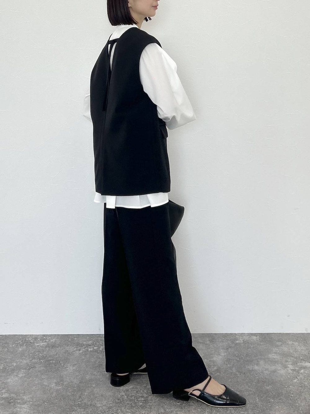 ブラック系のトートバッグ、ブラック系のスーツセット、ホワイト系のTシャツ/カットソーを着用したレディースの冬コーディネートの5枚目の写真