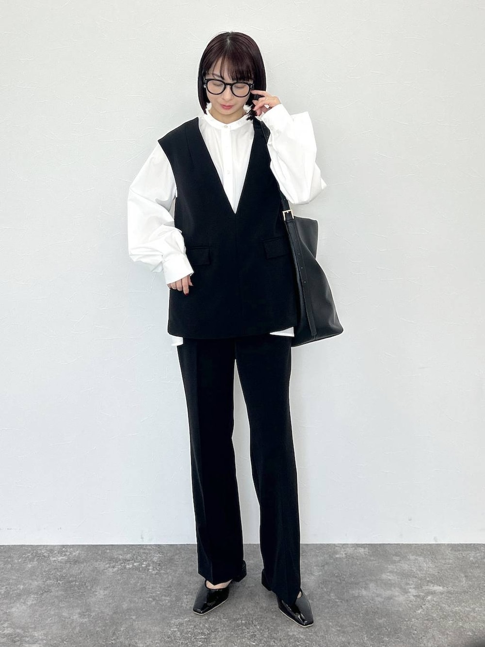 ブラック系のトートバッグ、ブラック系のスーツセット、ホワイト系のTシャツ/カットソーを着用したレディースの冬コーディネートの6枚目の写真