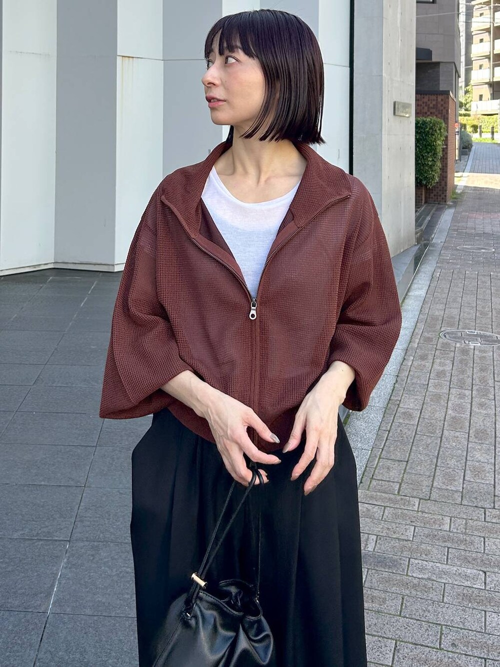ブラック系のショルダーバッグ、レッド系のブルゾン、ブラック系のスラックスを着用したレディースの夏コーディネートの6枚目の写真
