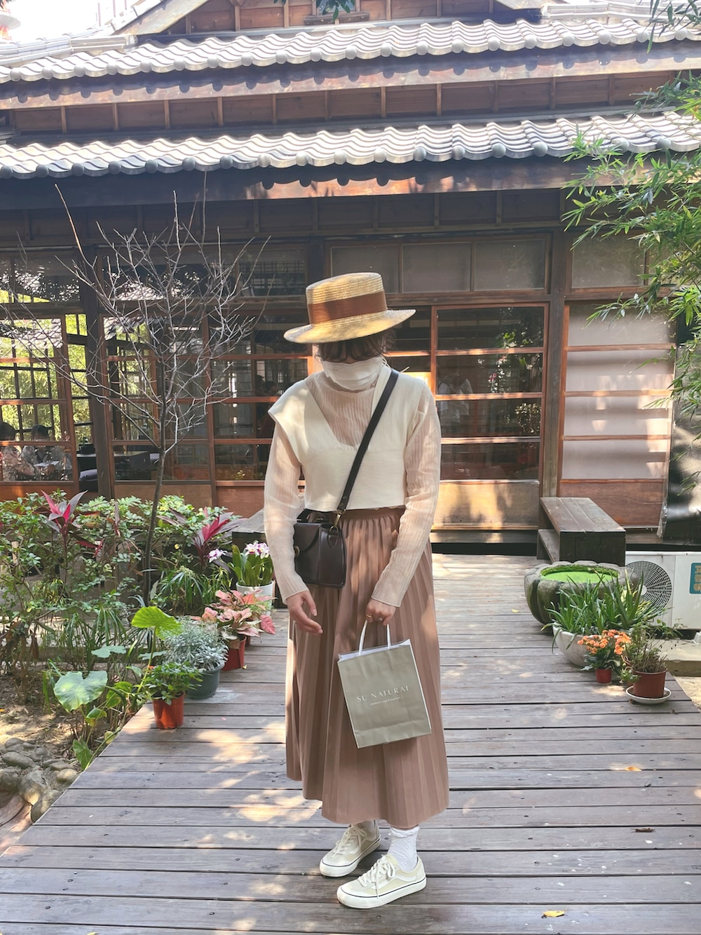 ホワイト系のシャツ/ブラウス、ホワイト系のベスト、ブラウン系のスカートを着用したレディースの春コーディネートの2枚目の写真