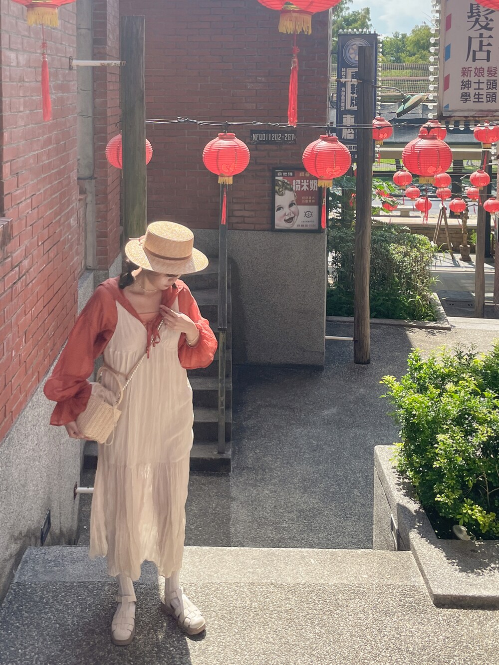 ホワイト系のワンピース、オレンジ系のシャツ/ブラウス、ベージュ系のかごバッグを着用したレディースの秋コーディネートの2枚目の写真