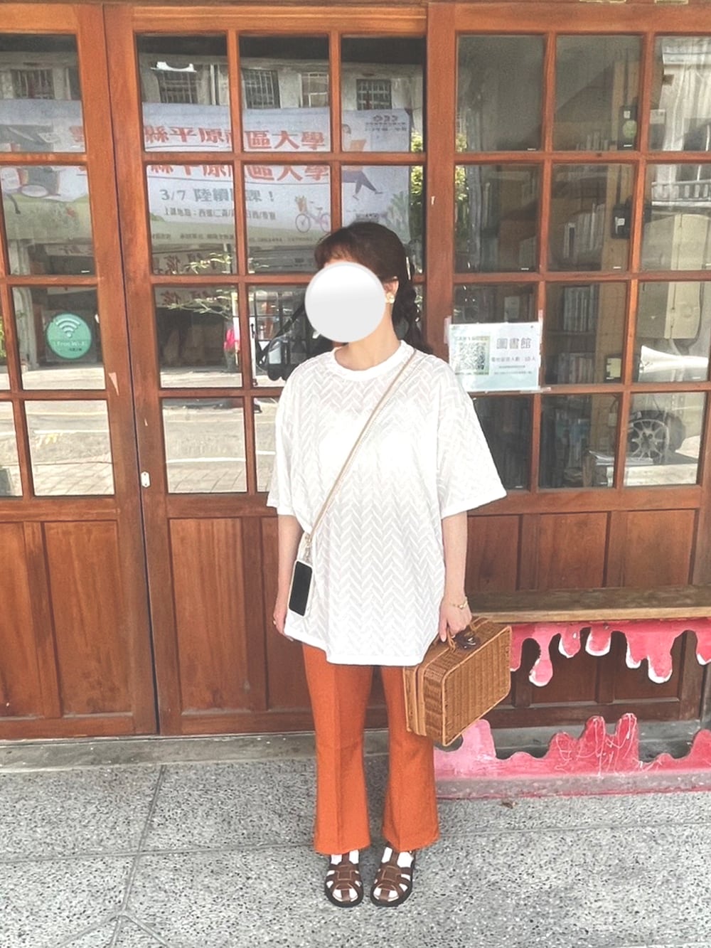 ホワイト系のTシャツ/カットソー、ブラック系のスラックス、ブラウン系のサンダルを着用したレディースの春コーディネートの2枚目の写真