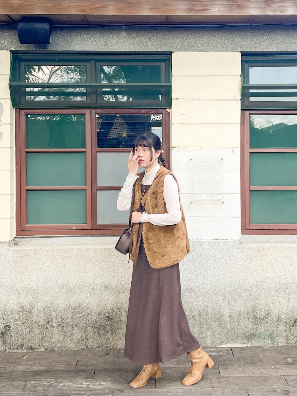 ブラウン系のベスト、ブラウン系のワンピース/ドレス、ブラウン系のブーツを着用したレディースの冬コーディネートの2枚目の写真