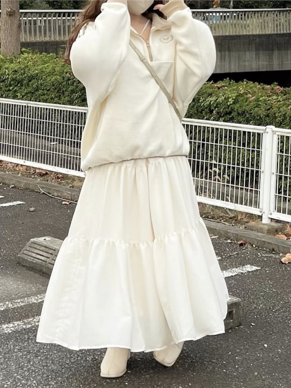 ベージュ系のショルダーバッグ、ホワイト系のスウェット、ホワイト系のスカートを着用したレディースの冬コーディネートの3枚目の写真