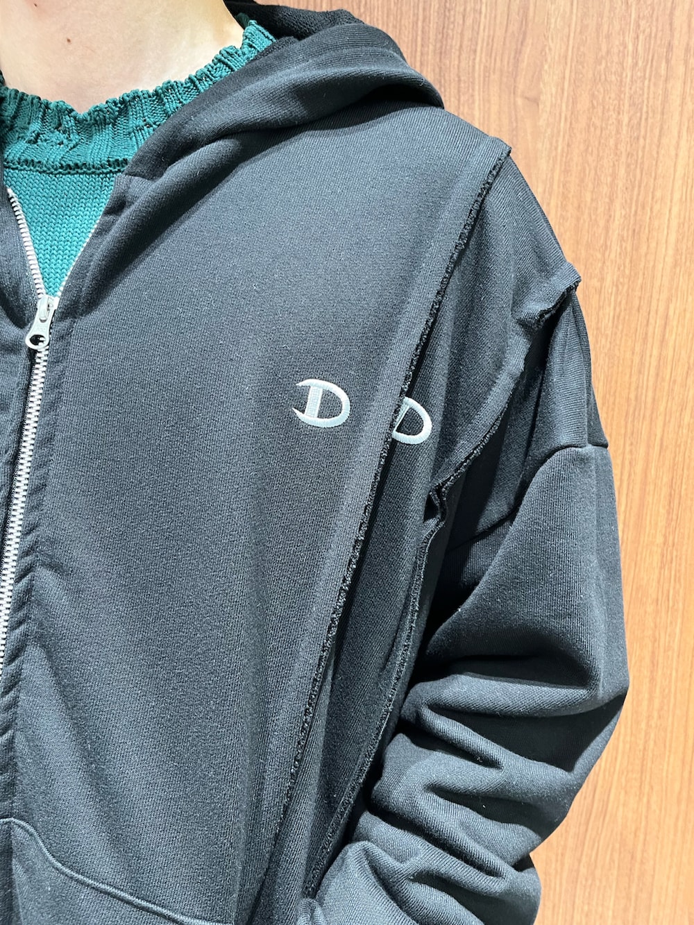 ブラック系のパーカー、グレー系のパーカー、ブラウン系のスラックスを着用したメンズの春コーディネートの2枚目の写真