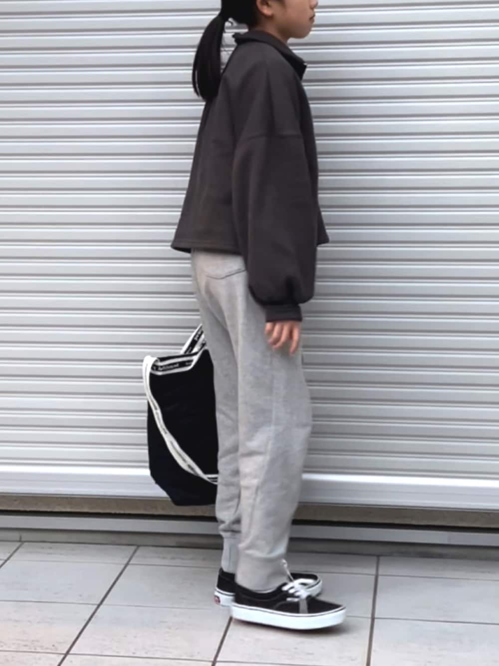 ブラック系のスウェット、ホワイト系のTシャツ/カットソー、グレー系のスウェットパンツを着用したキッズの冬コーディネートの2枚目の写真