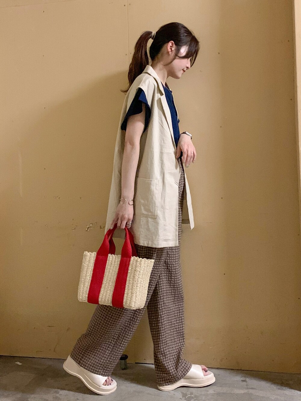 ブルー系のTシャツ/カットソー、レッド系のハンドバッグ、ホワイト系のサンダルを着用したレディースの夏コーディネートの3枚目の写真