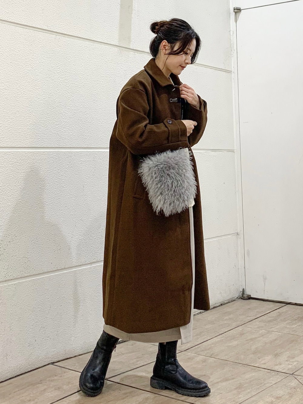 その他のニット/セーター、ブラウン系のステンカラーコート、ホワイト系のショルダーバッグを着用したレディースの秋コーディネートの2枚目の写真