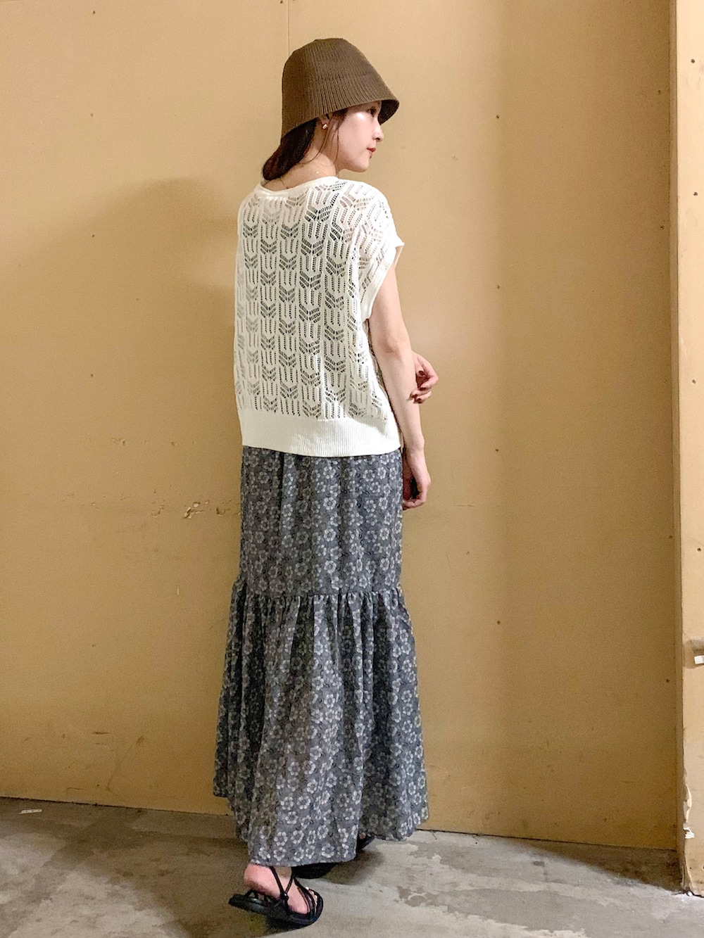 ベージュ系のベスト、グレー系のスカート、ホワイト系の音楽/本・雑誌を着用したレディースの夏コーディネートの2枚目の写真