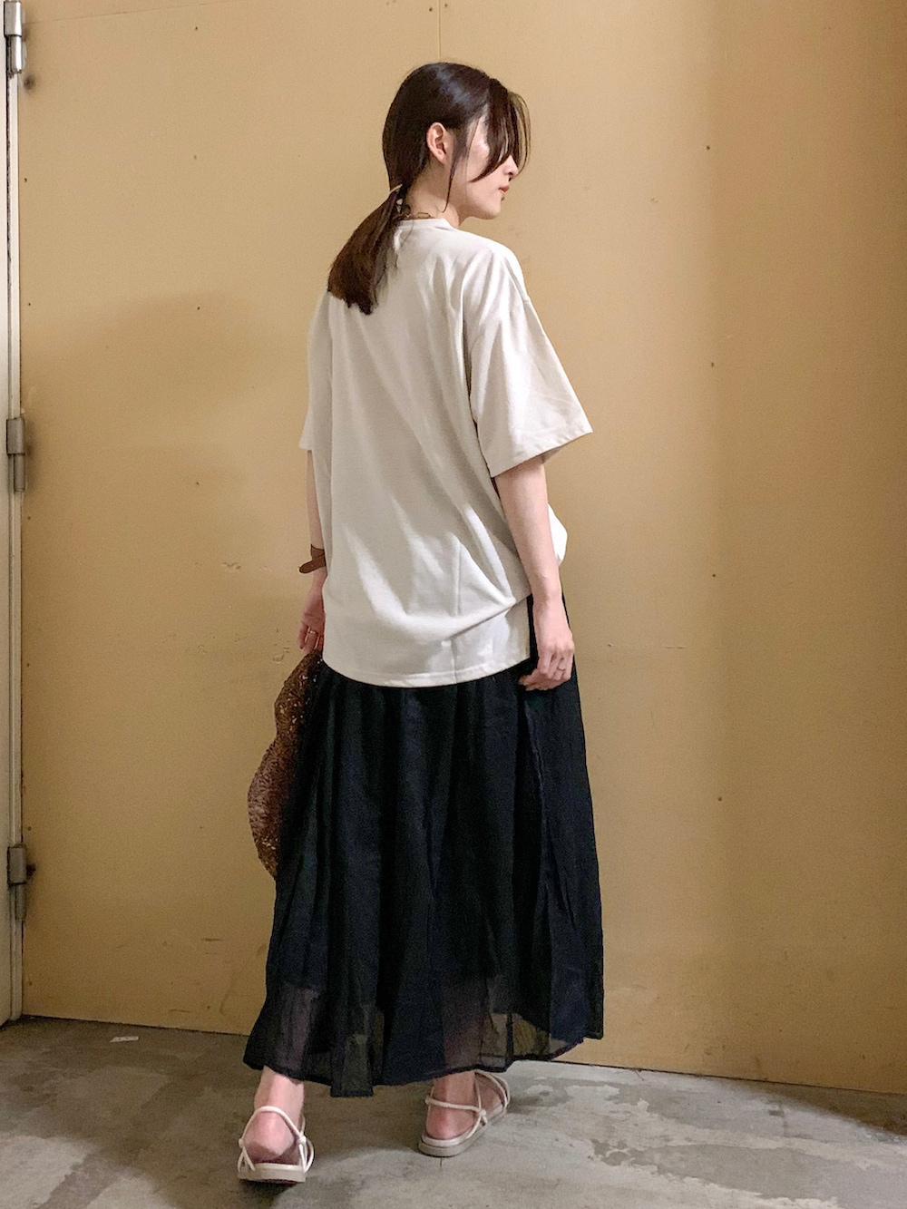 ベージュ系のTシャツ/カットソー、グリーン系のスカート、ホワイト系の音楽/本・雑誌を着用したレディースの夏コーディネートの3枚目の写真