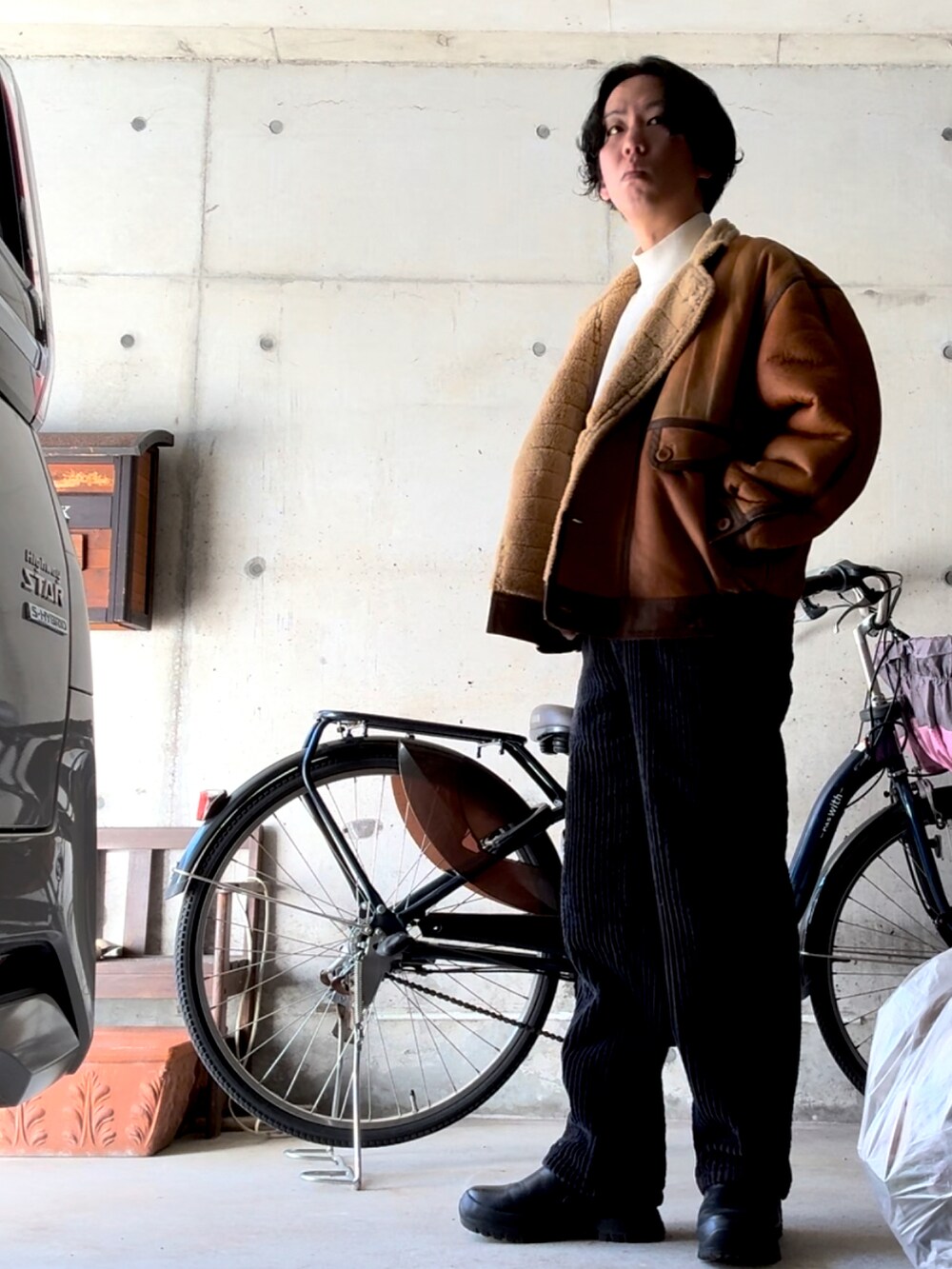 ブラウン系のジャケット/アウター、ブラック系のスラックス、ブラック系のブーツを着用したメンズの冬コーディネートの2枚目の写真