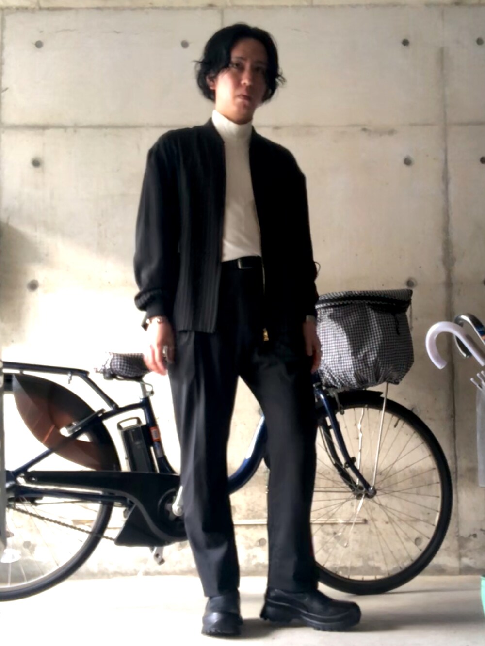 ブラック系のスラックス、ホワイト系のTシャツ/カットソー、ブラック系のMA-1を着用したメンズの春コーディネートの3枚目の写真