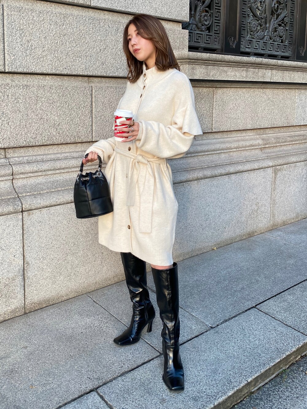 ホワイト系のカーディガン/ボレロ、ブラック系のブーツを着用したレディースの秋コーディネートの3枚目の写真