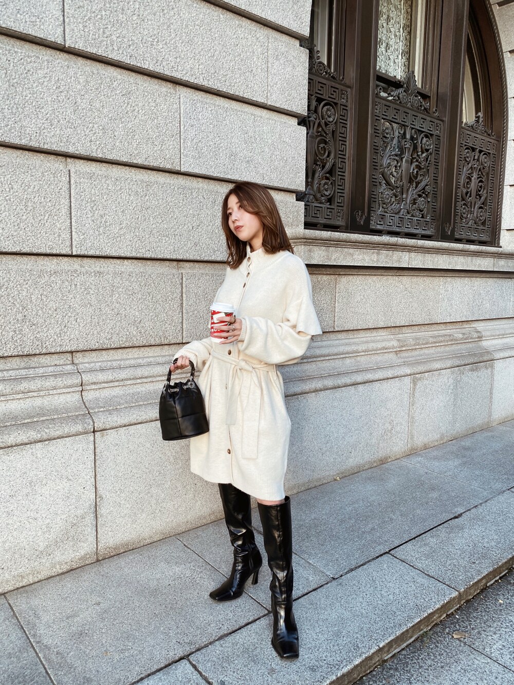 ホワイト系のカーディガン/ボレロ、ブラック系のブーツを着用したレディースの秋コーディネートの2枚目の写真