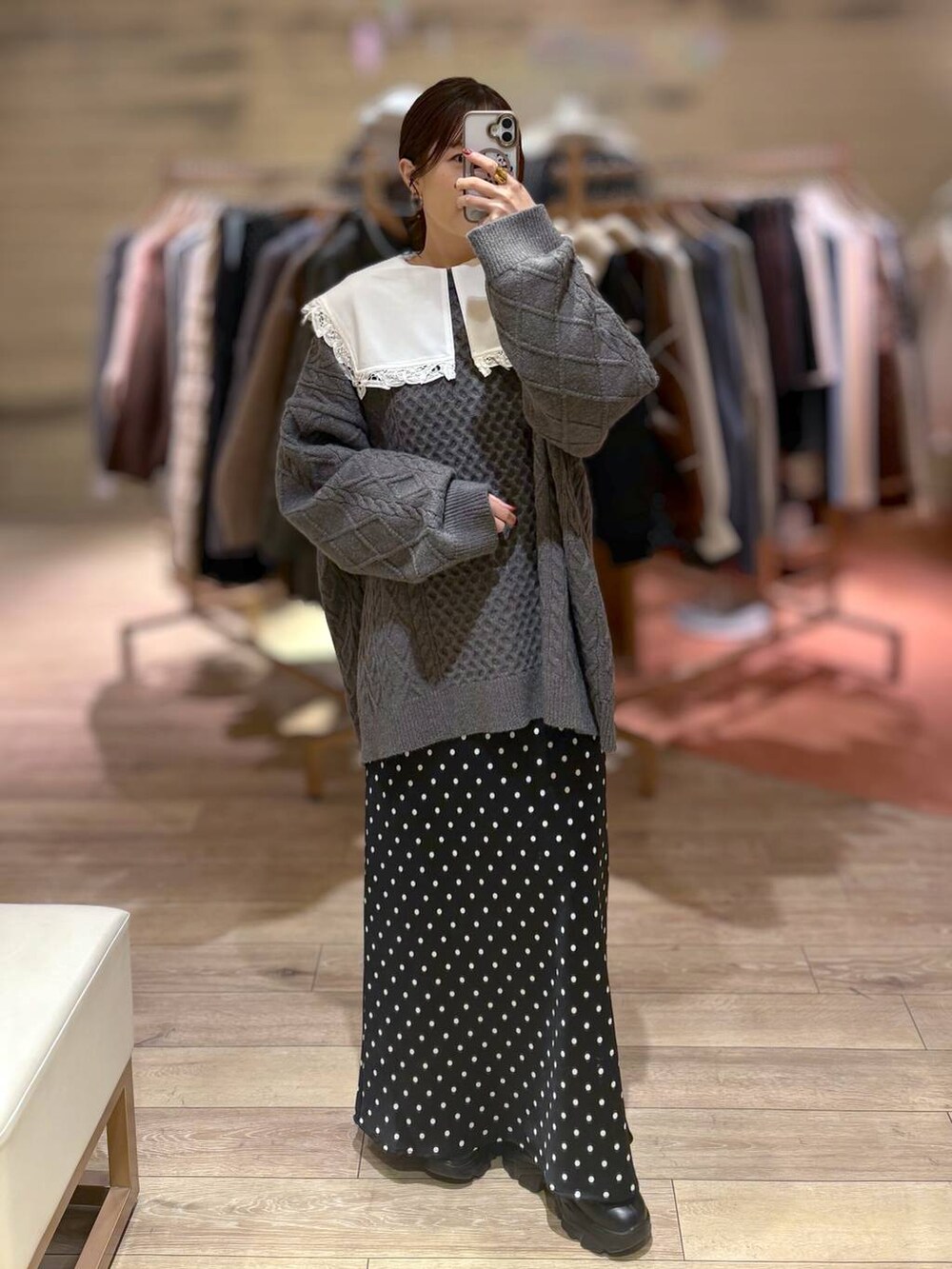 ブラック系のブーツ、ホワイト系のTシャツ/カットソー、ブラック系のスカートを着用したレディースの冬コーディネートの3枚目の写真