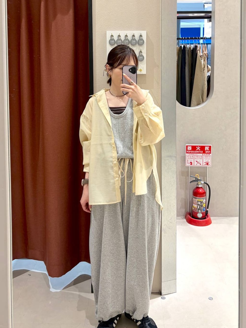 イエロー系のシャツ/ブラウス、ブラウン系のタンクトップ、グレー系のサロペット/オーバーオールを着用したレディースの春コーディネートの2枚目の写真