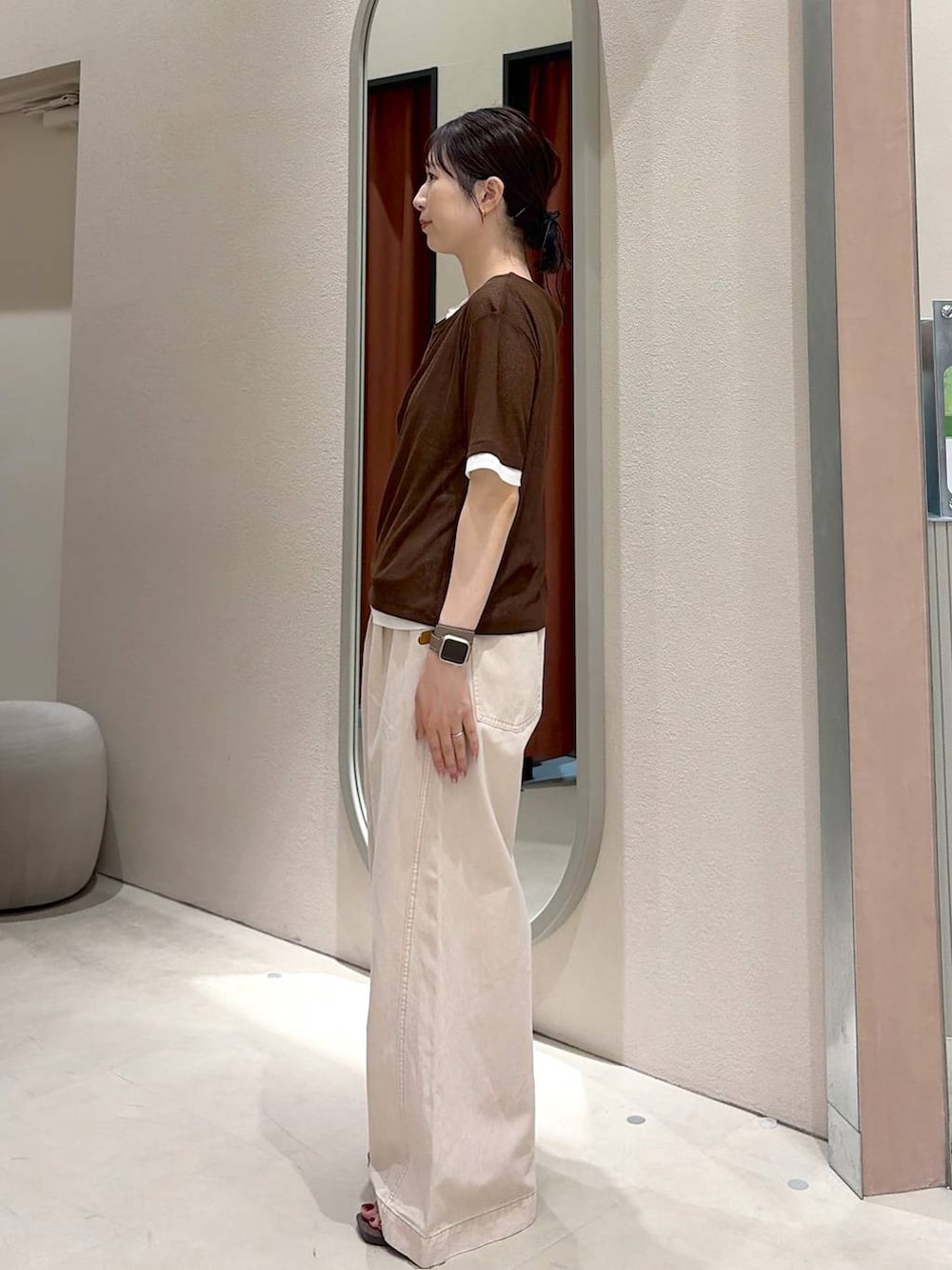 ピンク系のデニムパンツ、ブラウン系のサンダル、ブラウン系のTシャツ/カットソーを着用したレディースの春コーディネートの2枚目の写真