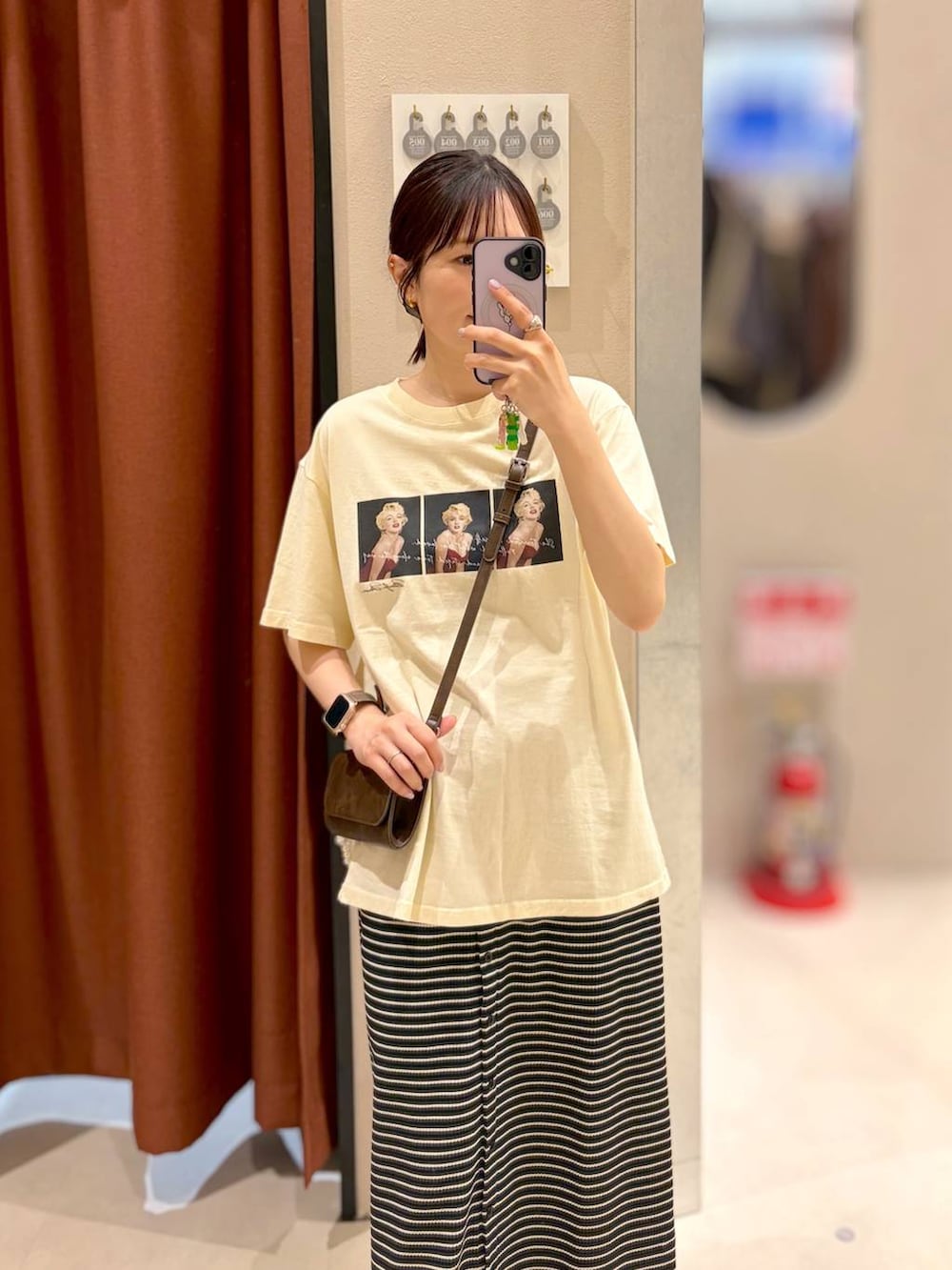 ブラック系のサンダル、ブラウン系のボディバッグ/ウエストポーチ、ベージュ系のTシャツ/カットソーを着用したレディースの夏コーディネートの2枚目の写真