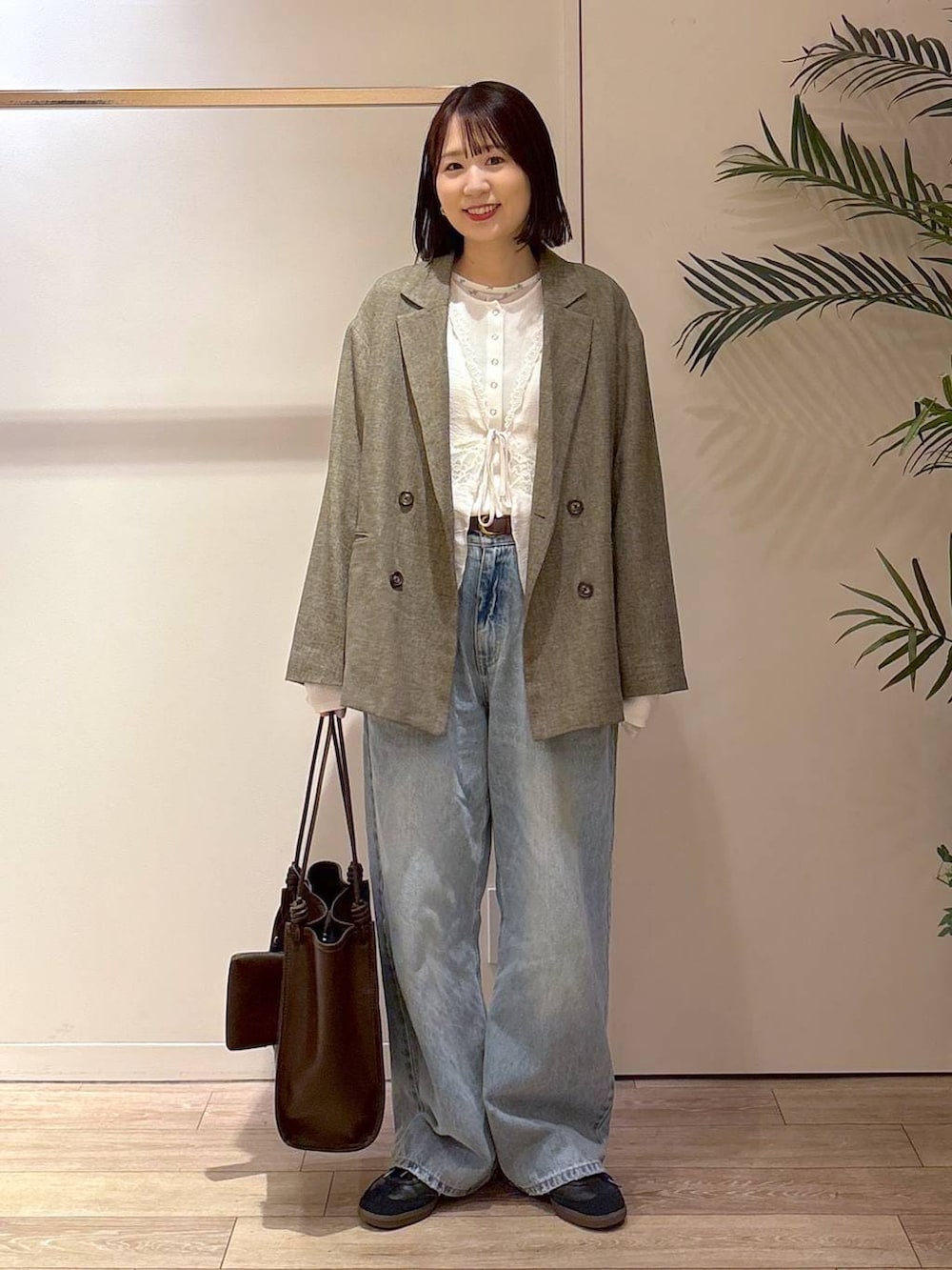 ホワイト系のニット/セーター、ブラウン系のテーラードジャケット、ホワイト系のTシャツ/カットソーを着用したレディースの春コーディネートの2枚目の写真