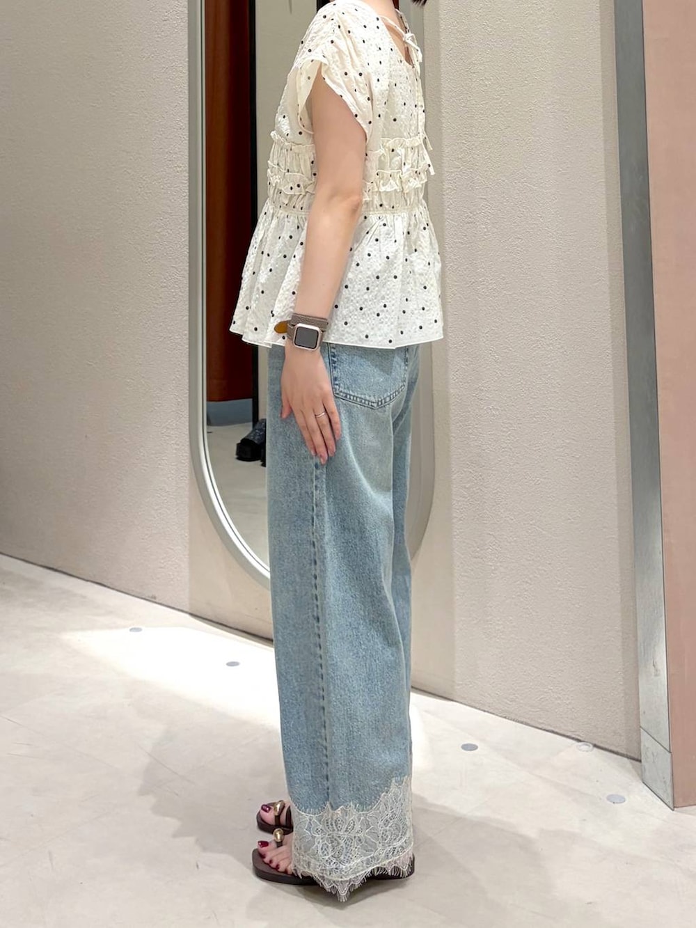 ブルー系のデニムパンツ、ブラウン系のサンダル、ブラウン系のトートバッグを着用したレディースの春コーディネートの4枚目の写真