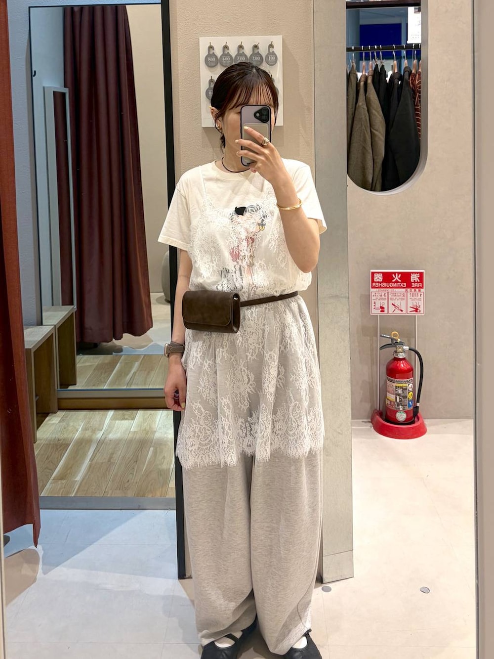 グレー系のスウェットパンツ、ブラウン系のボディバッグ/ウエストポーチ、ホワイト系のTシャツ/カットソーを着用したレディースの春コーディネートの2枚目の写真