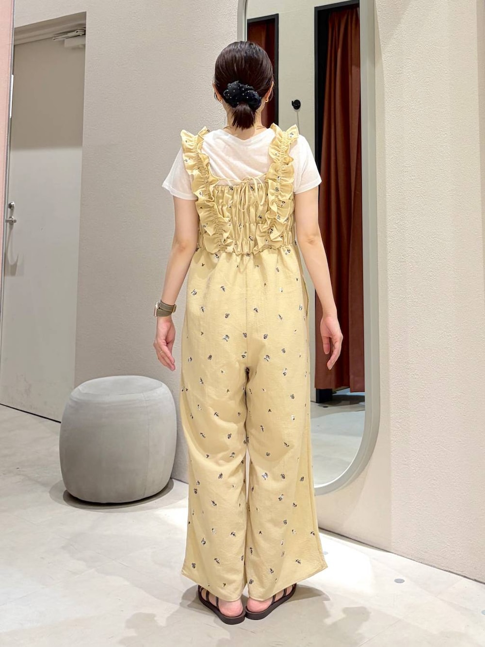 ベージュ系のサロペット/オーバーオール、ブラウン系のサンダル、ホワイト系のTシャツ/カットソーを着用したレディースの夏コーディネートの3枚目の写真
