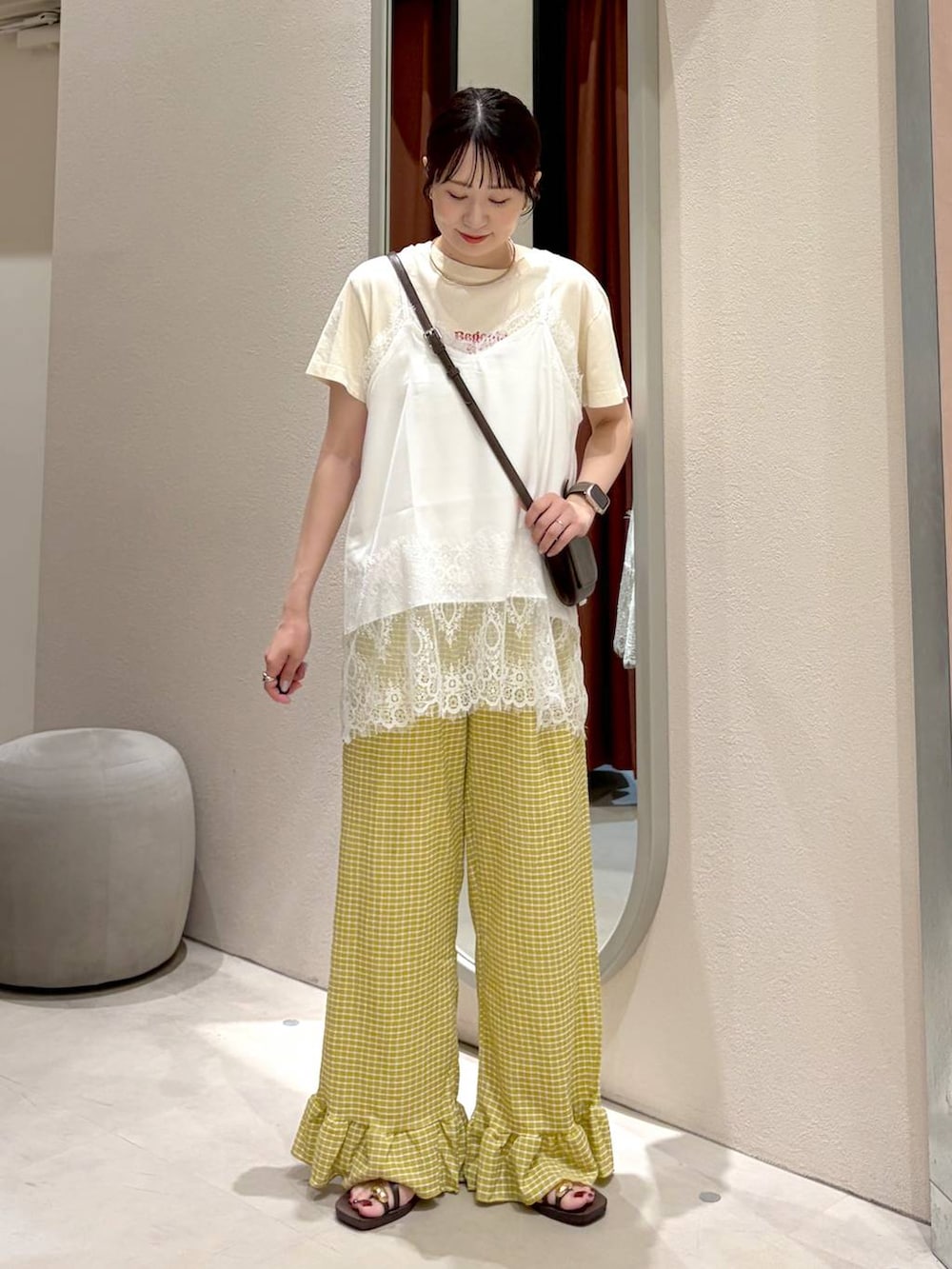 ブラウン系のサンダル、ブラウン系のボディバッグ/ウエストポーチ、ホワイト系のTシャツ/カットソーを着用したレディースの夏コーディネートの2枚目の写真