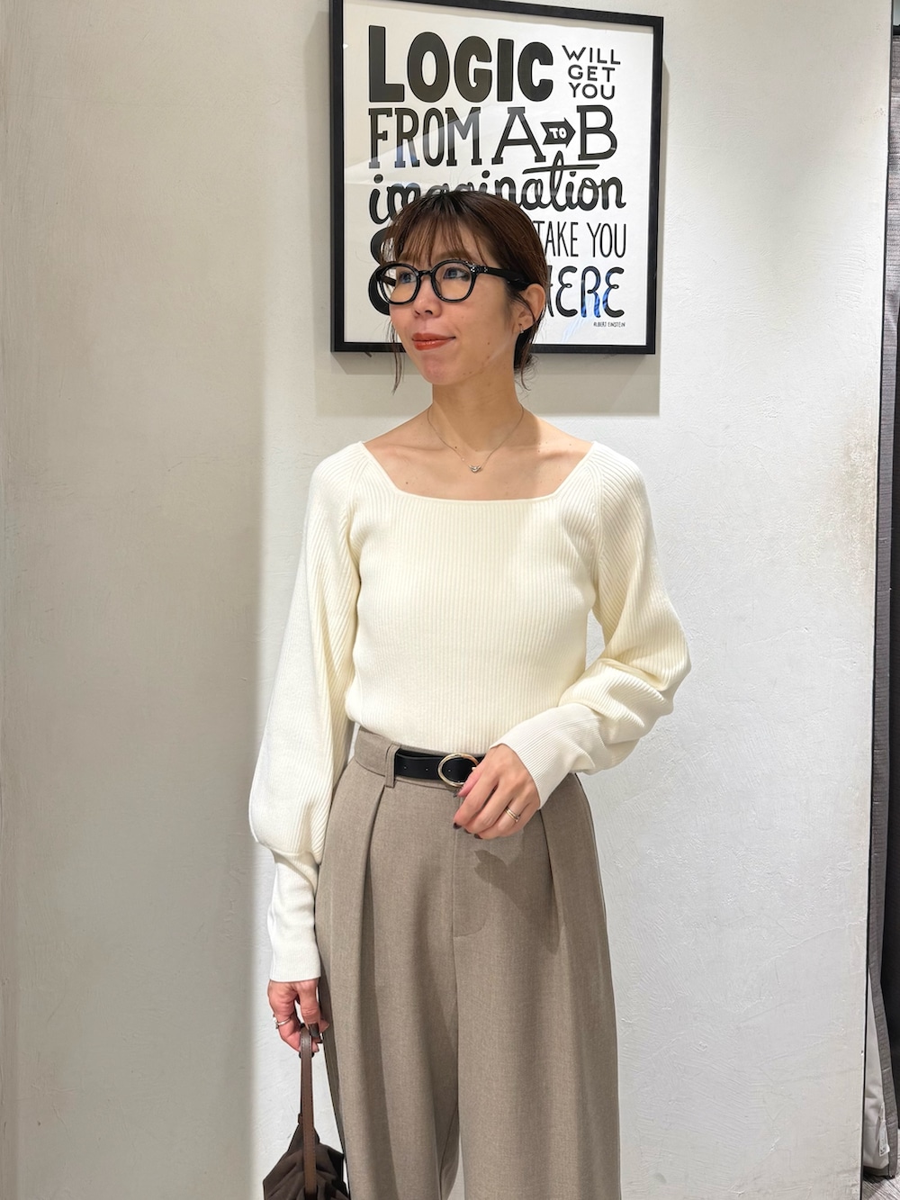 ホワイト系のニット/セーター、ベージュ系のその他パンツ、ブラウン系のショルダーバッグを着用したレディースの冬コーディネートの5枚目の写真