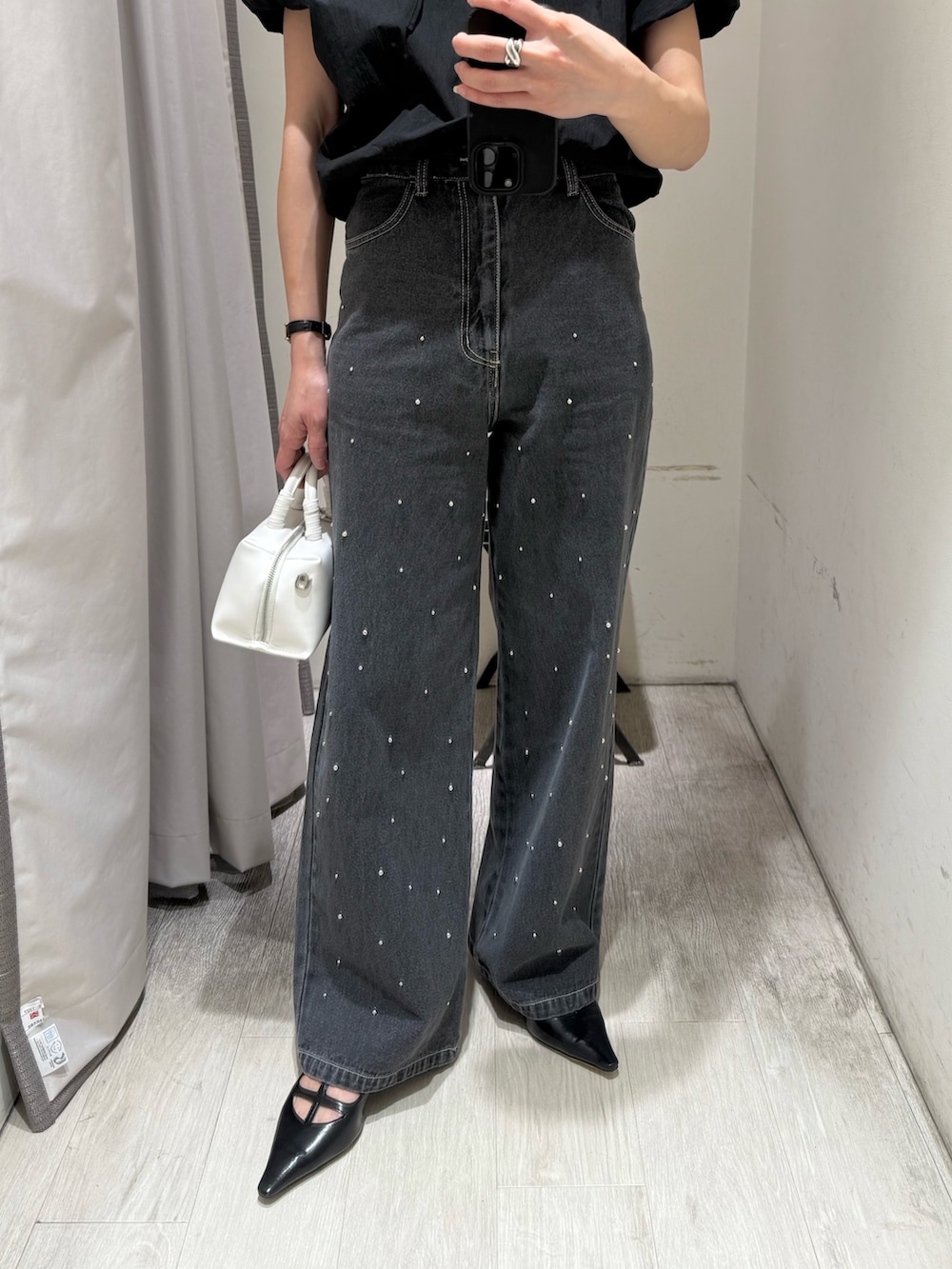 ブラック系のシャツ/ブラウス、ブラック系のデニムパンツ、ホワイト系のショルダーバッグを着用したレディースの春コーディネートの3枚目の写真