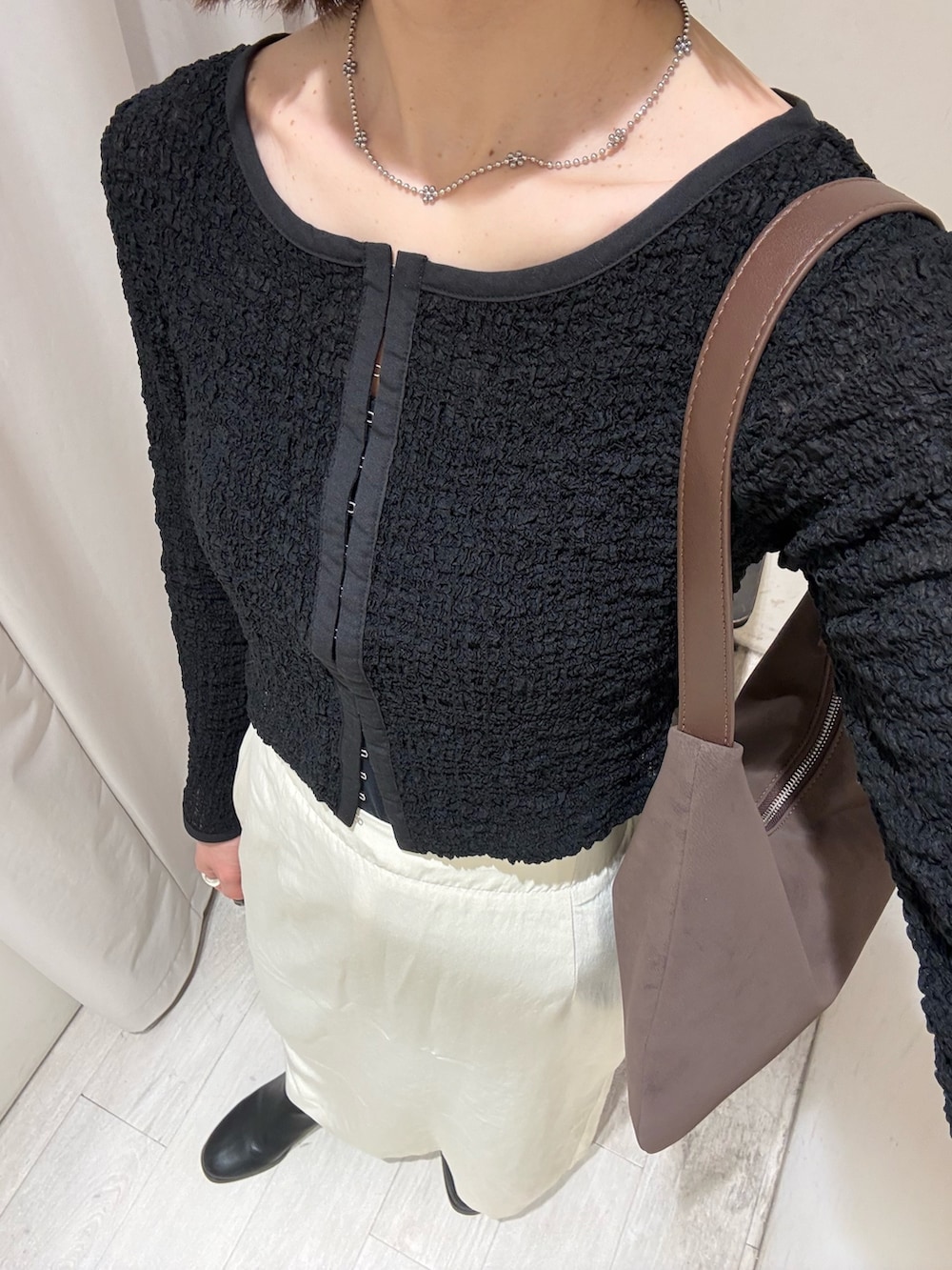 ブラック系のシャツ/ブラウス、ブラウン系のショルダーバッグ、ホワイト系のスカートを着用したレディースの冬コーディネートの3枚目の写真