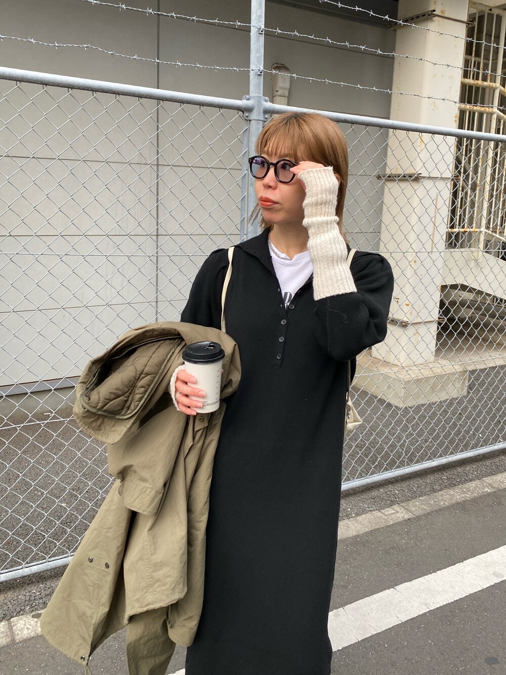 ブラック系のブーツ、ブラック系のワンピース、ベージュ系のバックパック/リュックを着用したレディースの冬コーディネートの2枚目の写真