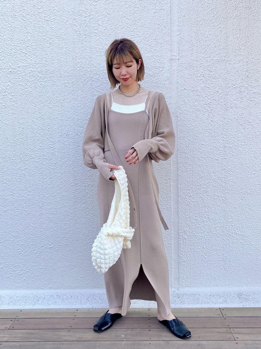 ホワイト系のキャミソール、ベージュ系のワンピース、ホワイト系のトートバッグを着用したレディースの夏コーディネートの2枚目の写真