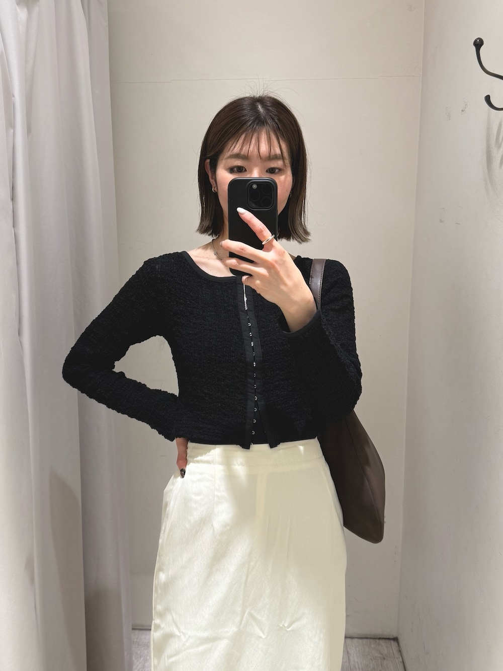 ブラック系のシャツ/ブラウス、ブラウン系のショルダーバッグ、ホワイト系のスカートを着用したレディースの冬コーディネートの2枚目の写真