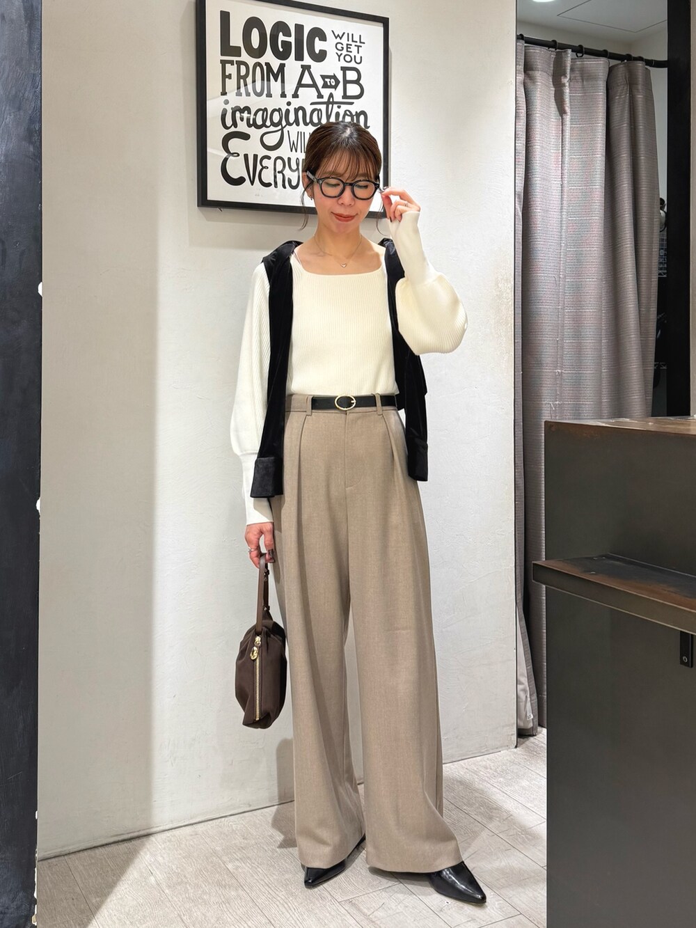 ホワイト系のニット/セーター、ベージュ系のその他パンツ、ブラウン系のショルダーバッグを着用したレディースの冬コーディネートの2枚目の写真