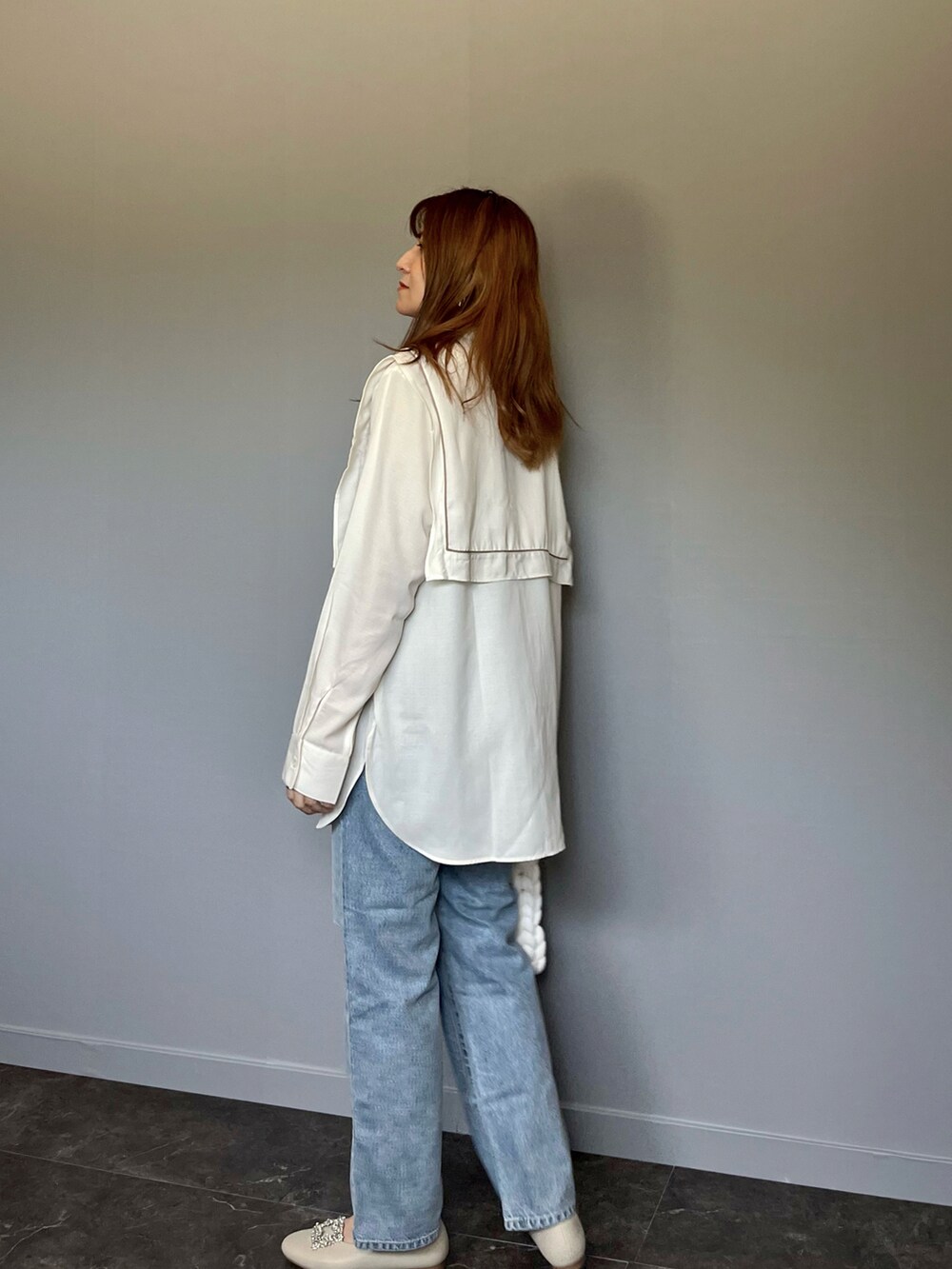 ブルー系のデニムパンツ、ホワイト系のシャツ/ブラウス、ホワイト系のハンドバッグを着用したレディースの春コーディネートの2枚目の写真