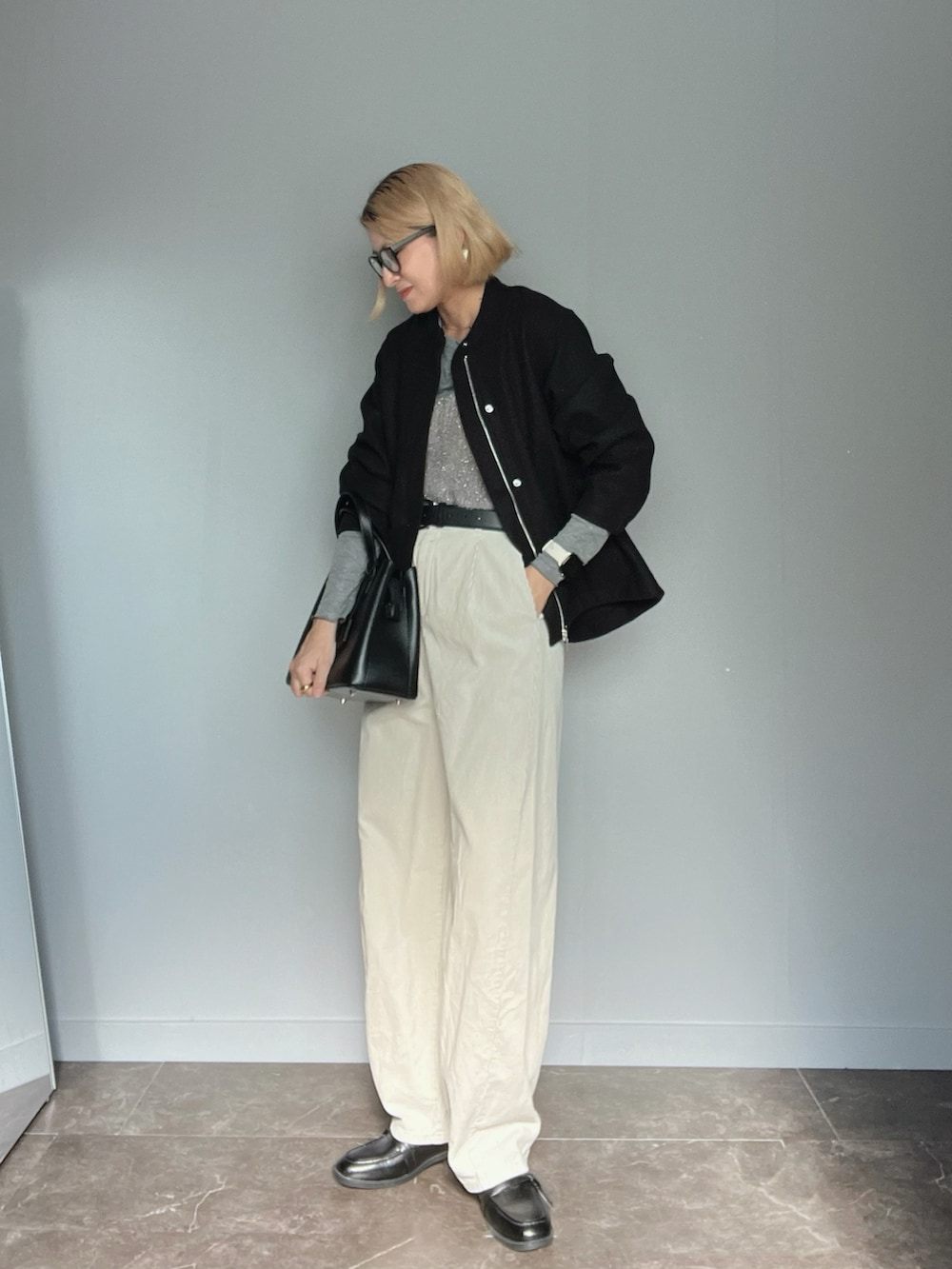 ブラック系のノーカラージャケット、グレー系のTシャツ/カットソー、ホワイト系のパンツを着用したレディースの秋コーディネートの2枚目の写真