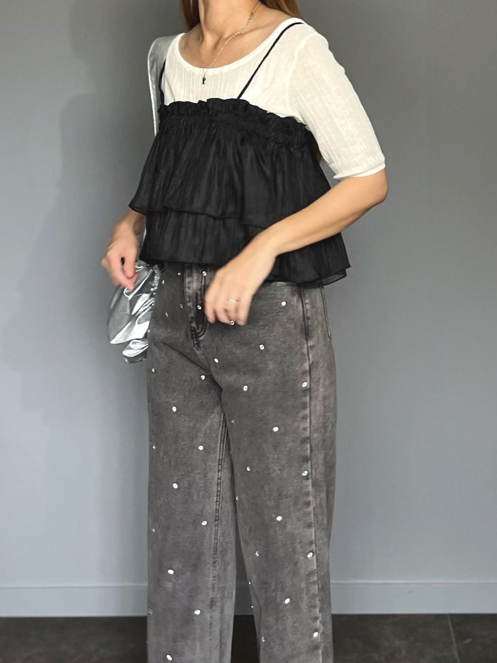 ブラック系のキャミソール、ホワイト系のニット/セーター、ブラック系のサンダルを着用したレディースの夏コーディネートの2枚目の写真