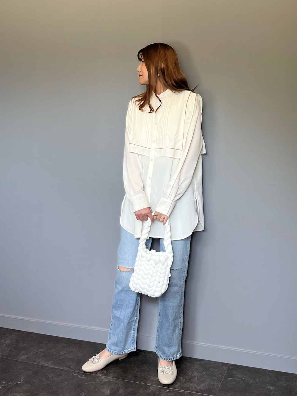 ブルー系のデニムパンツ、ホワイト系のシャツ/ブラウス、ホワイト系のハンドバッグを着用したレディースの春コーディネートの3枚目の写真