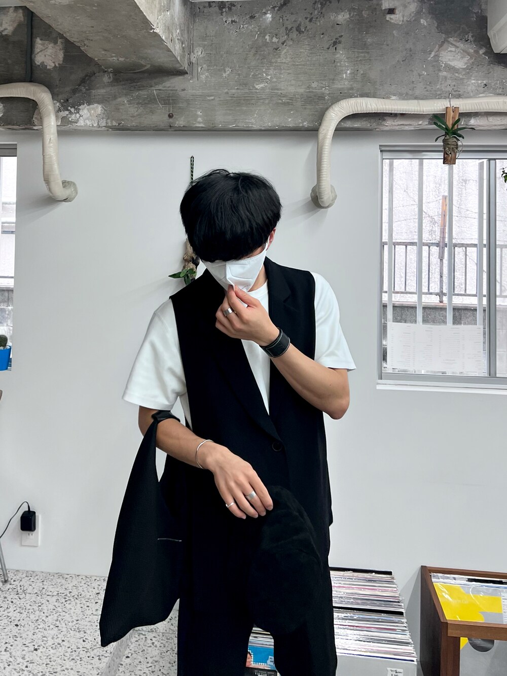 ブラック系のベスト、ブラック系のハンドバッグ、ホワイト系のTシャツ/カットソーを着用したメンズの秋コーディネートの2枚目の写真