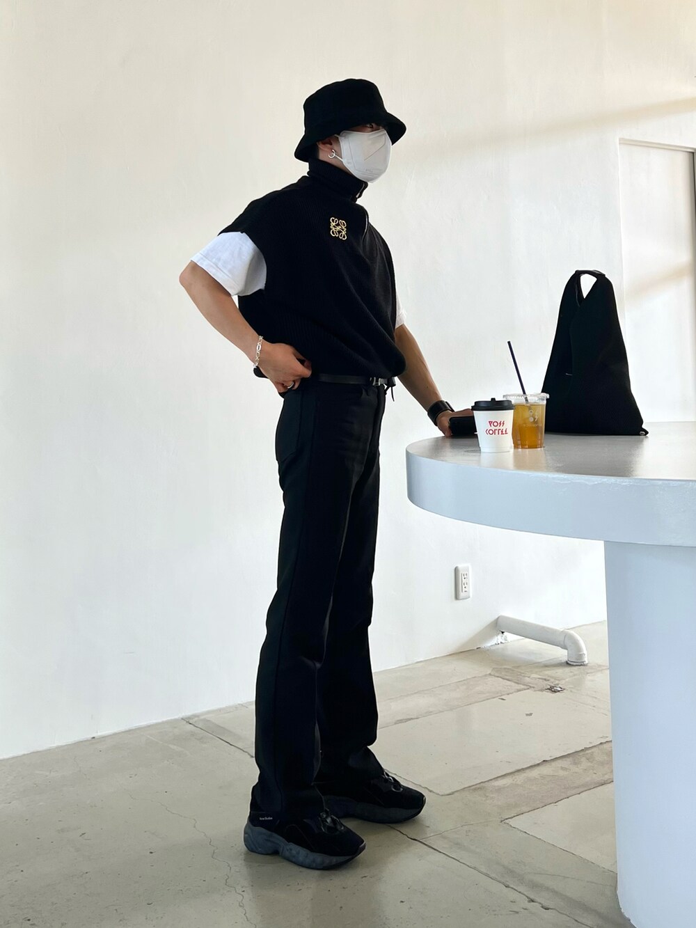 ブラック系のベスト、ブラック系のスラックス、ブラック系のスニーカーを着用したメンズの春コーディネートの2枚目の写真