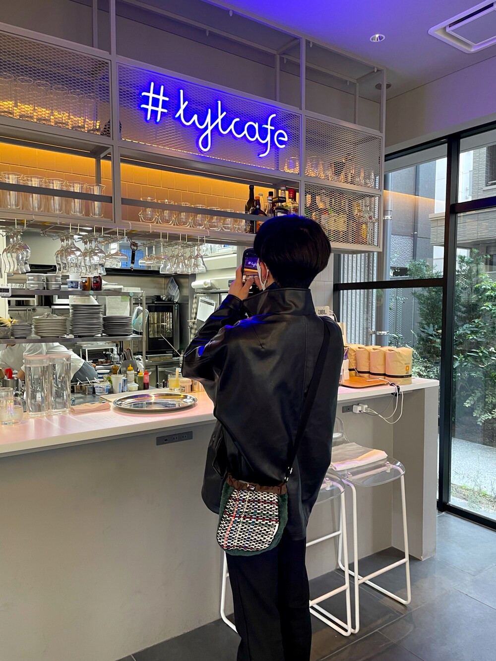 グリーン系のバッグ、ブラック系のジャケット/アウターを着用したメンズの春コーディネートの2枚目の写真