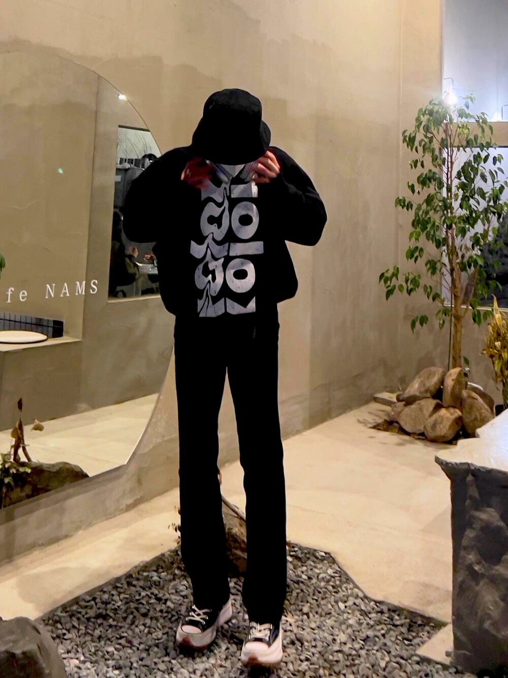 ブラック系のスウェット、ブラック系のスニーカー、ブラック系のその他パンツを着用したメンズの冬コーディネートの2枚目の写真