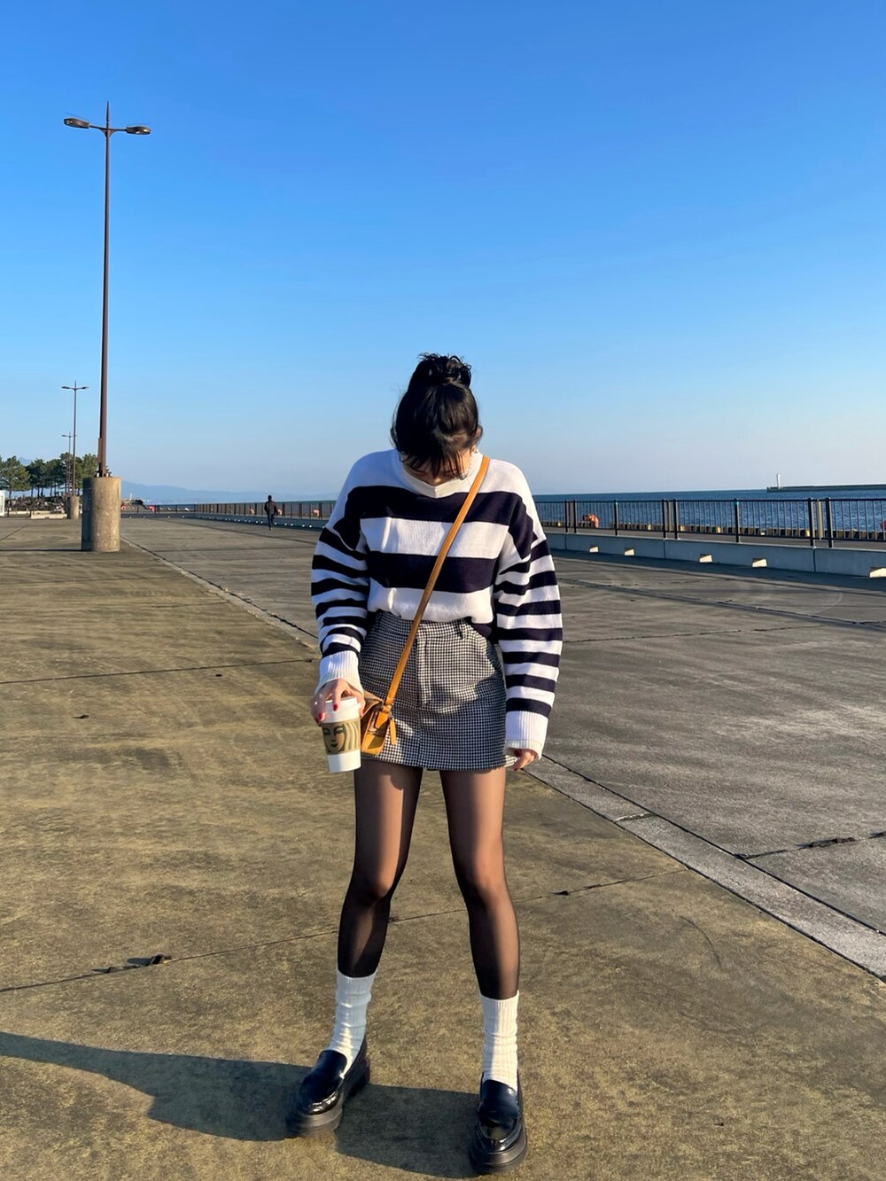 ベージュ系のショルダーバッグ、ホワイト系のニット/セーター、ホワイト系のニット/セーターを着用したレディースの冬コーディネートの2枚目の写真