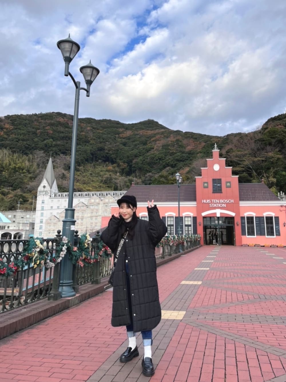 ブラック系のダウンジャケット/コート、ブラック系のローファー、ブラック系のショルダーバッグを着用したレディースの冬コーディネートの2枚目の写真