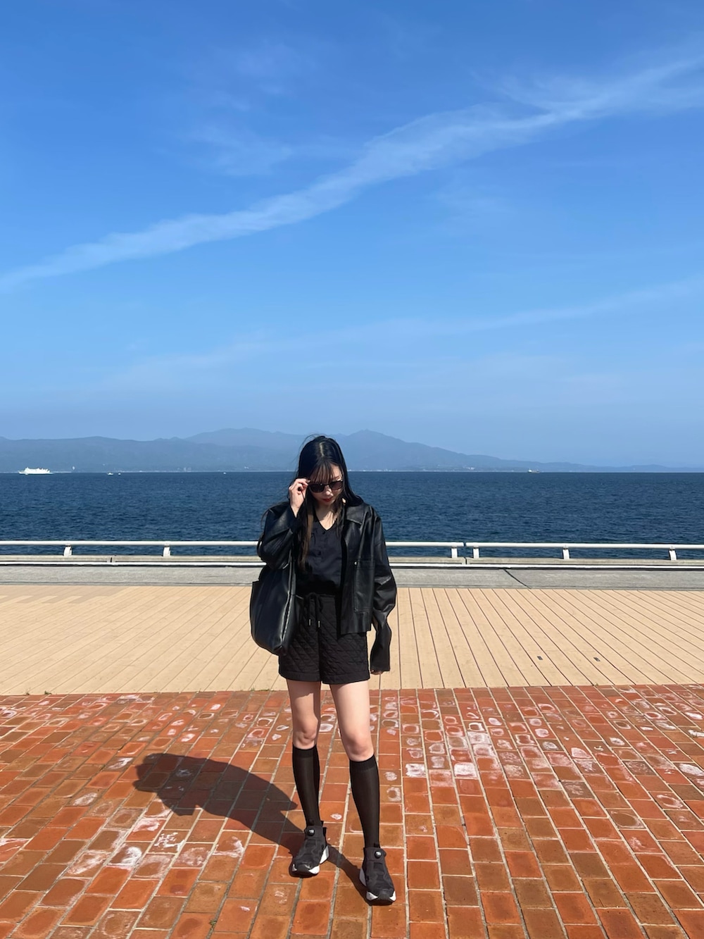 ブラック系のシャツ/ブラウス、ブラック系のその他パンツ、ブラック系のスニーカーを着用したレディースの春コーディネートの2枚目の写真