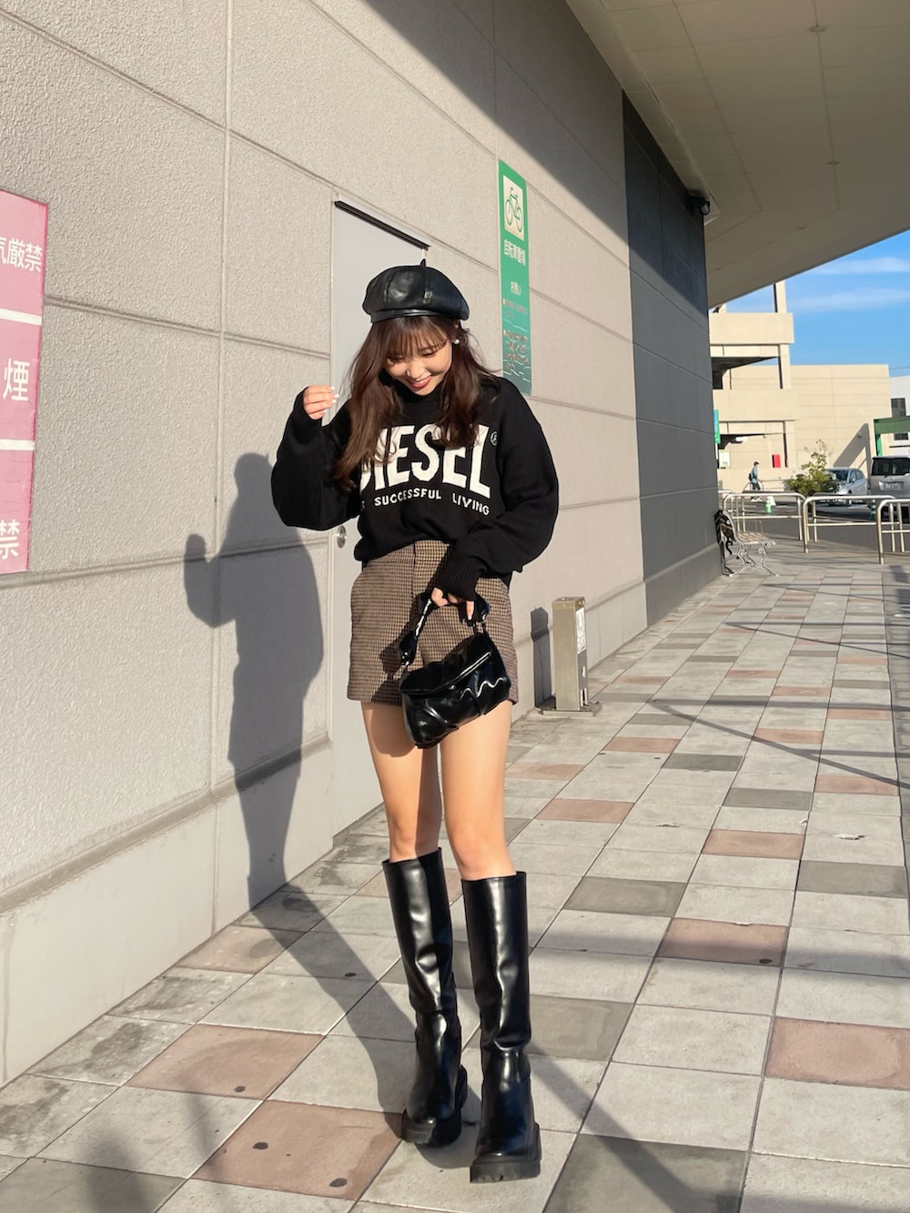 ブラック系のバッグ、ブラウン系のパンツ、ブラック系のブーツを着用したレディースの秋コーディネートの3枚目の写真